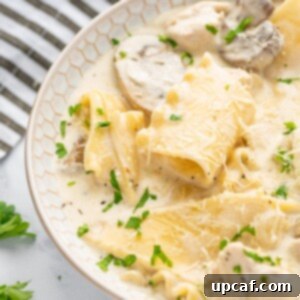 Creamy Chicken Lasagna Soup 11 A bowl of easy white lasagna soup with a striped napkin in the background.