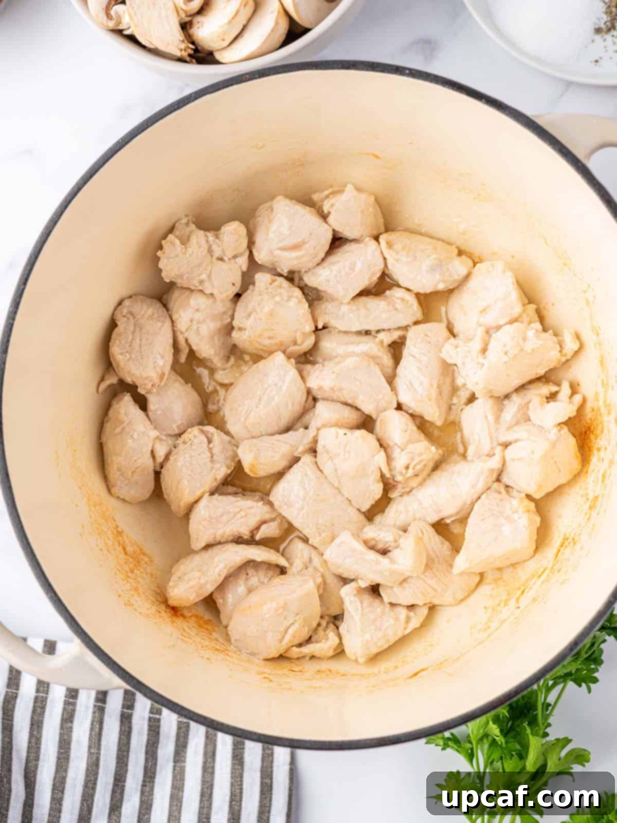 Creamy Chicken Lasagna Soup 4 Cubed chicken cooked in a Dutch oven, lightly browned and ready to be removed.