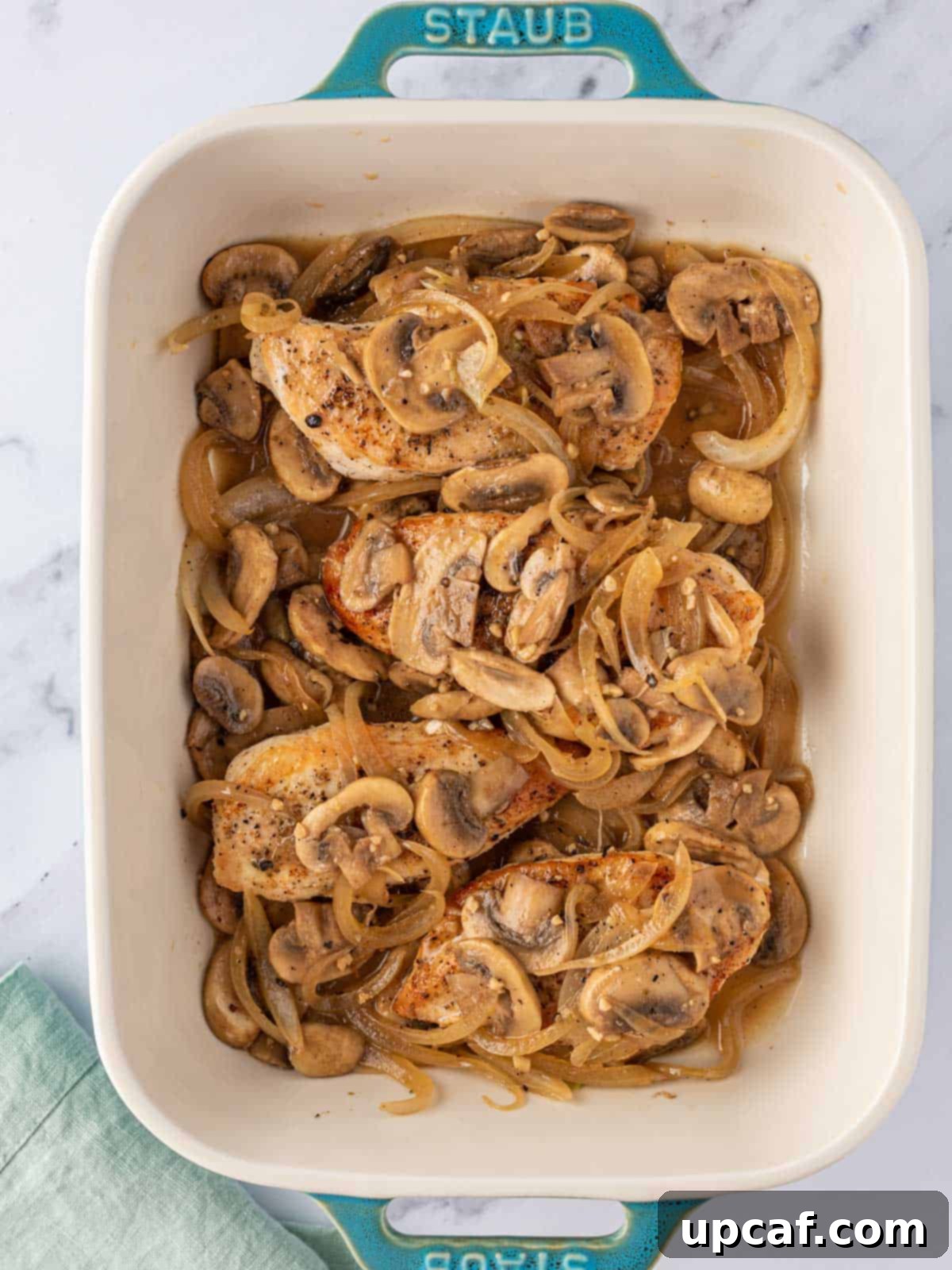 Remaining mushroom mixture spooned over chicken breasts in the baking dish.