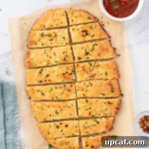 Overhead view of low carb garlic bread cut into rectangular slices with marinara on the side.