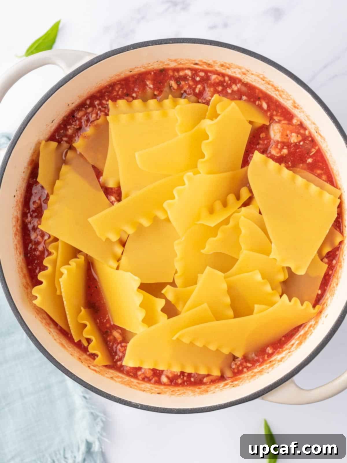 Adding broken noodles for lasagna soup.