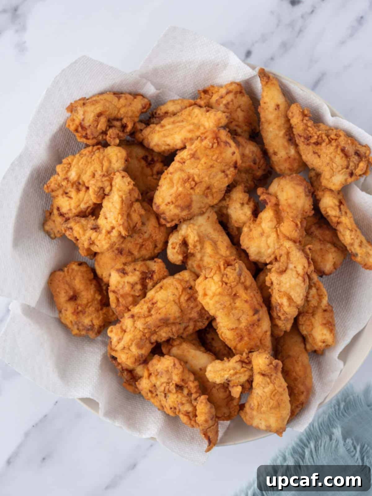 KFC's Fiery Nashville Chicken Tenders 6 A bowl filled with freshly fried, golden-brown chicken tenders, ready for sauce.