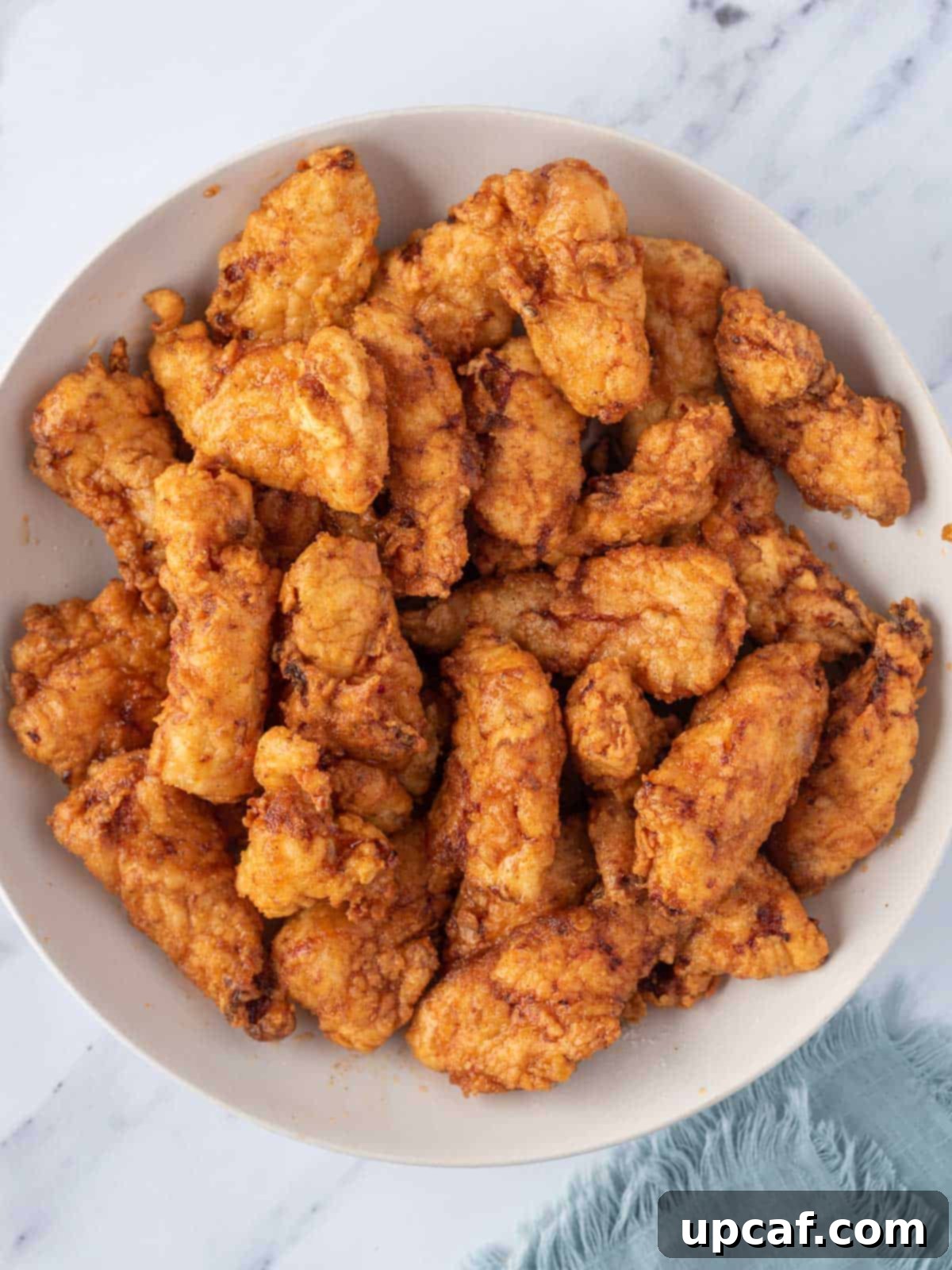 KFC's Fiery Nashville Chicken Tenders 8 A bowl of Nashville hot chicken tenders generously coated in the signature red sauce.