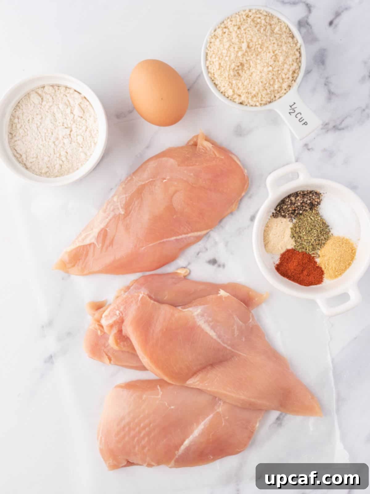 All the ingredients for air fryer chicken cutlets laid out on a kitchen counter.