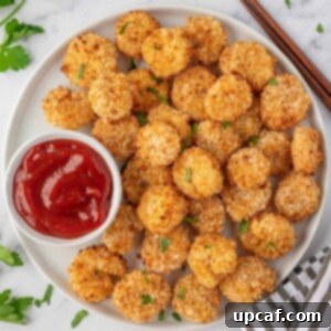 Crispy air fryer popcorn shrimp served on a plate with ketchup.