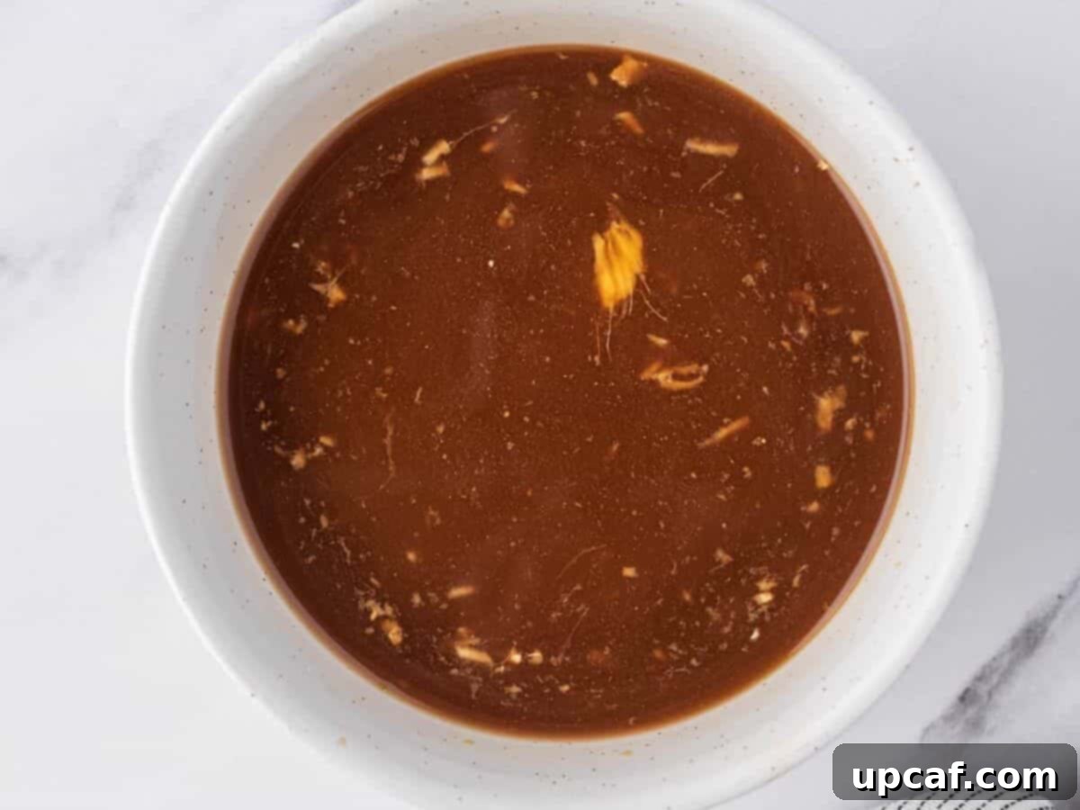 A small white dish filled with the prepared chicken stir fry sauce.