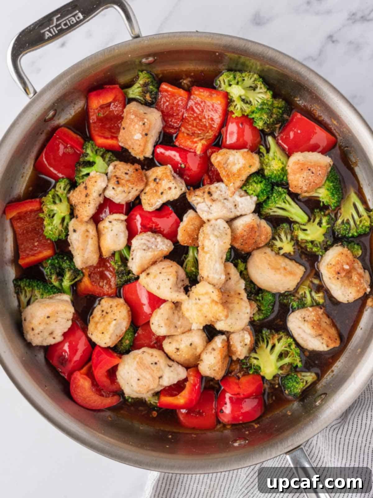 A skillet with perfectly cooked chicken, vibrant vegetables, and glistening chicken stir-fry sauce.