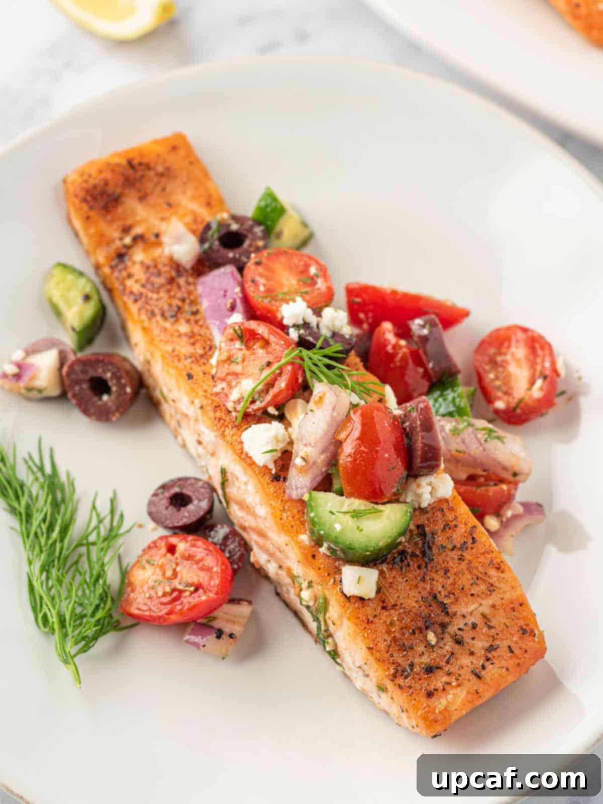 A close-up view of a succulent Greek salmon fillet, generously topped with vibrant Greek salsa.