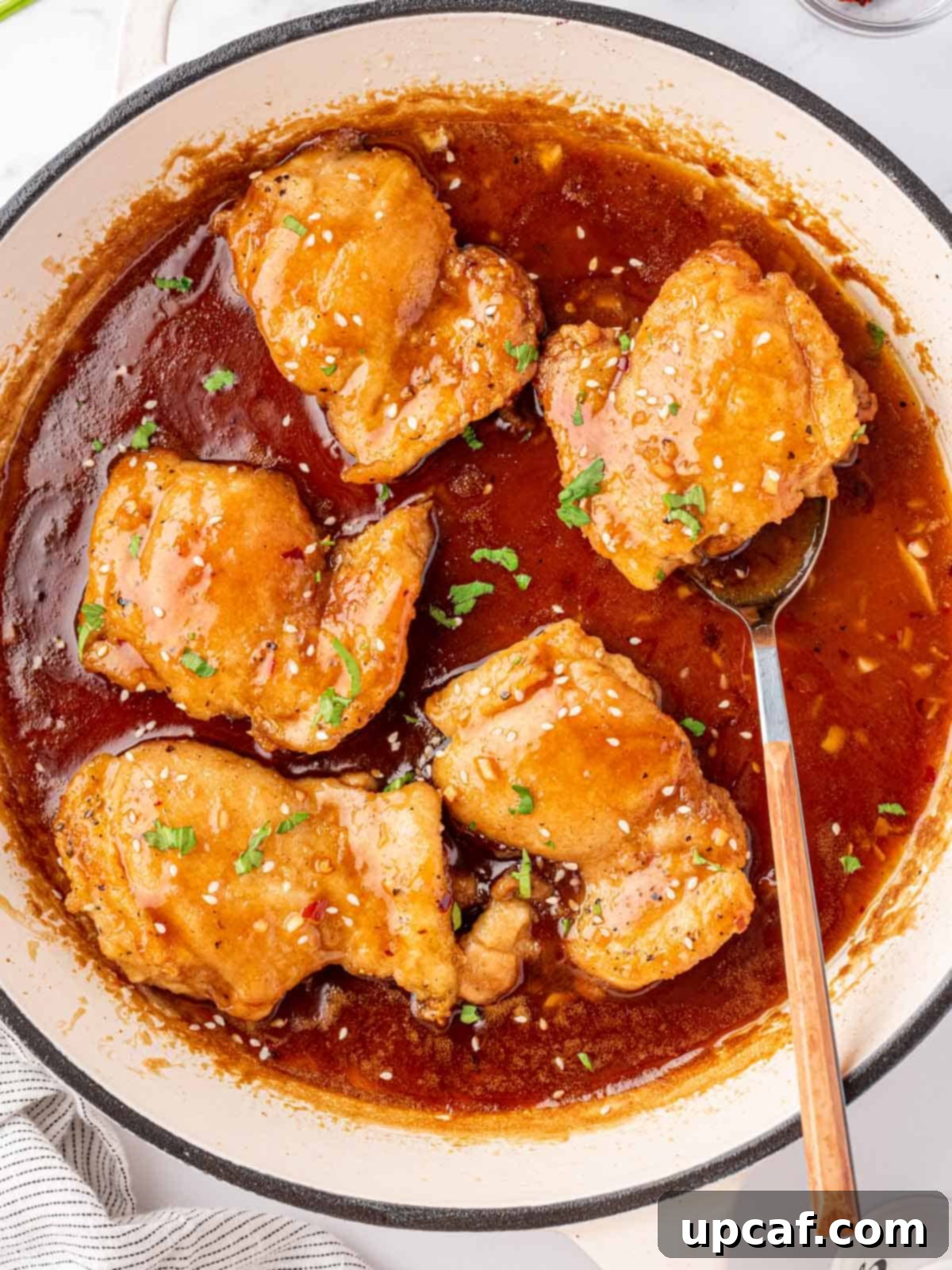 Honey and soy chicken thighs cooked and simmering in a pan, ready to be served.