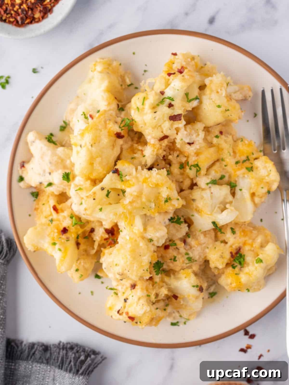 Cheesy Keto Cauliflower Bake 10 Keto mac and cheese in a bowl with a fork.