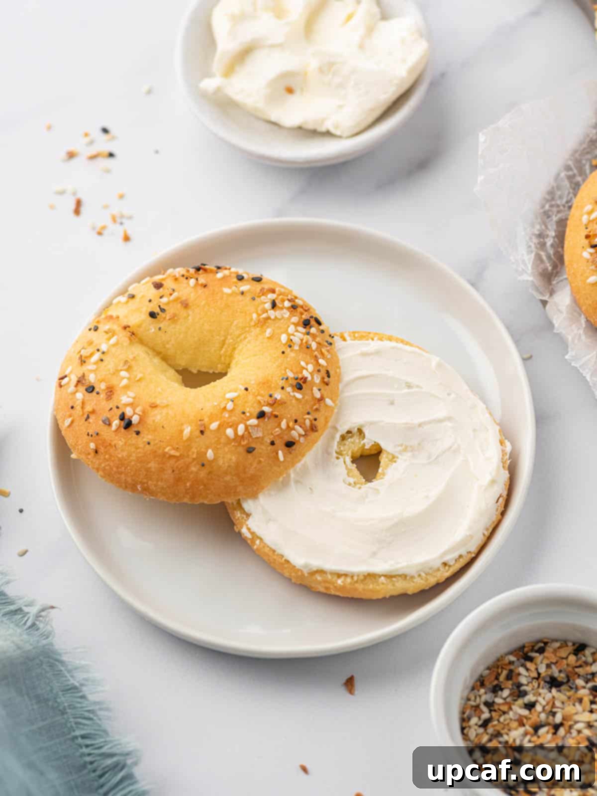 Guilt-Free Everything Keto Bagels 9 Low carb everything bagel sliced in half and smeared with cream cheese.