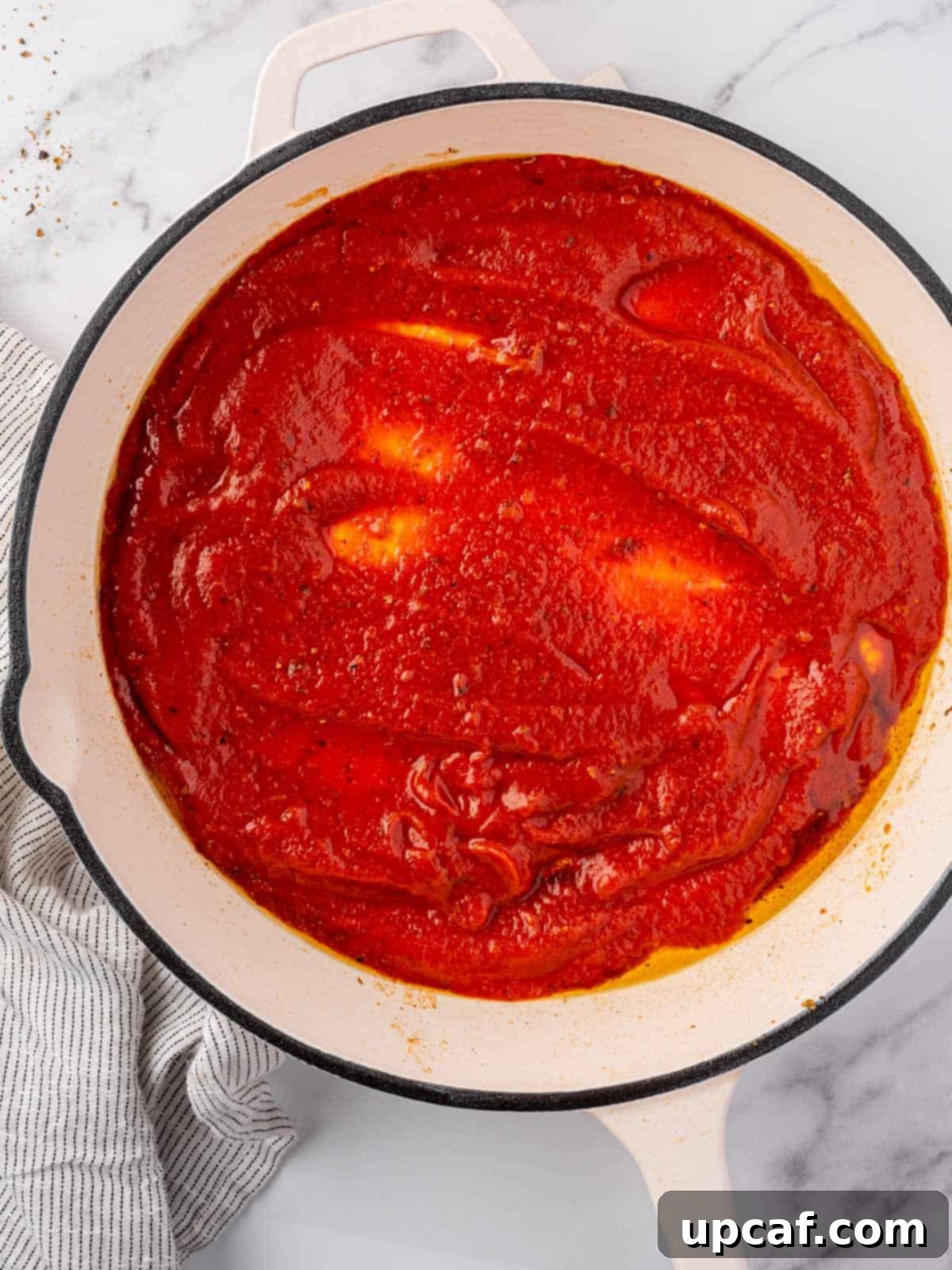 Keto Chicken Parm Skillet 6 Rich red marinara sauce simmering in a pan, infused with herbs and spices.