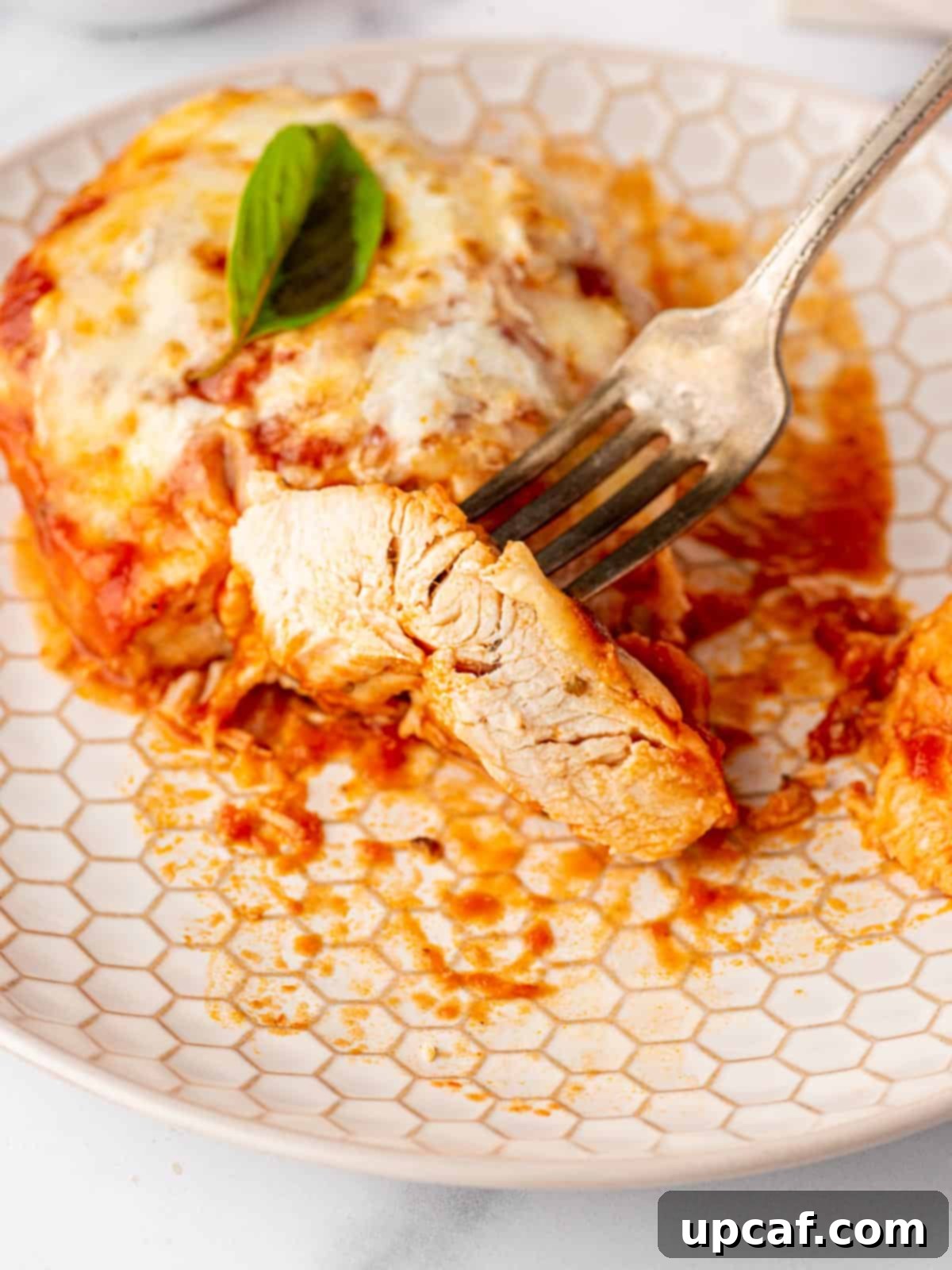 Keto Chicken Parm Skillet 9 A perfectly sliced piece of low carb chicken parmesan, showcasing the tender chicken, sauce, and melted cheese layers.