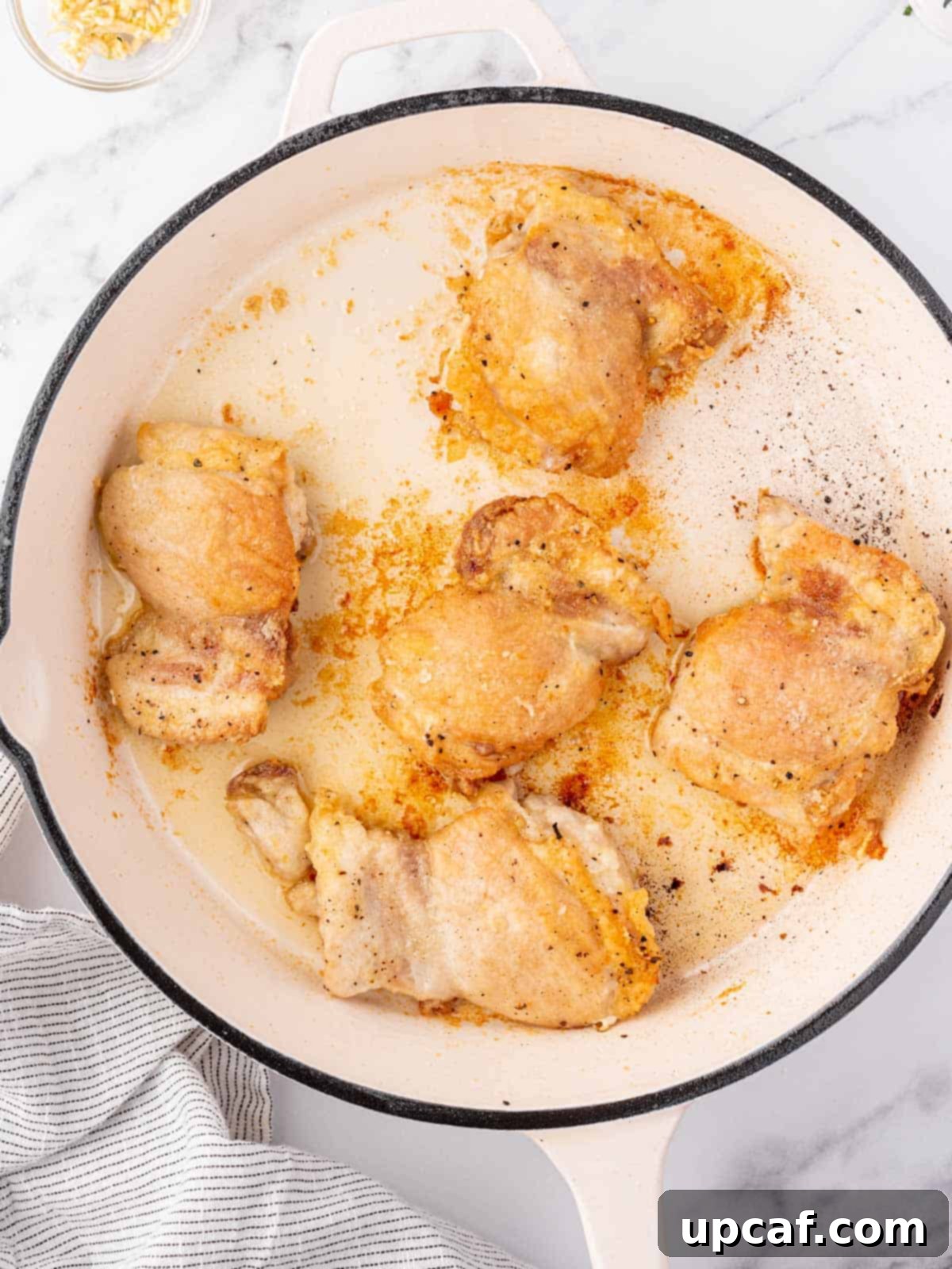 Chicken seared in a pan.