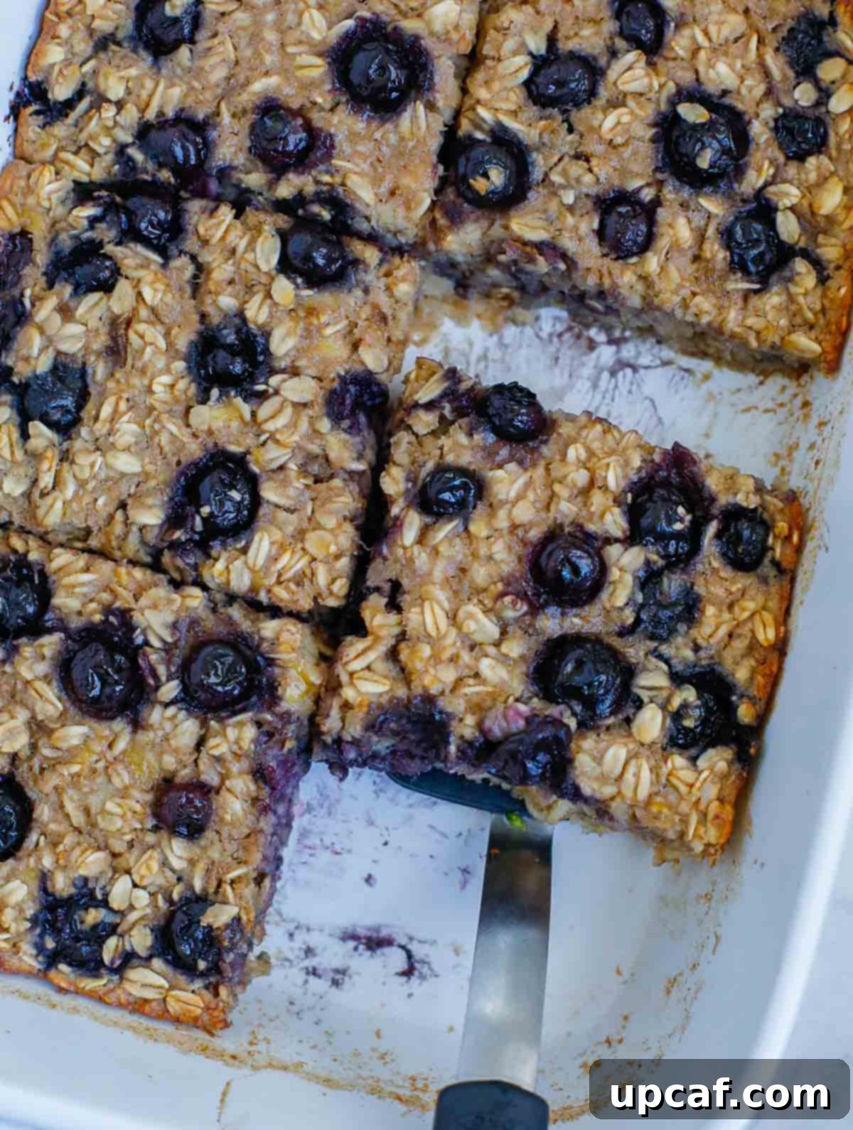 Hearty Blueberry Baked Oatmeal 7 A close-up shot of the blueberry baked oatmeal in a baking dish after being perfectly baked, showcasing its golden top, juicy blueberries, and inviting texture.