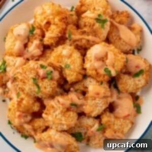A pile of air fryer panko shrimp with bang bang sauce.