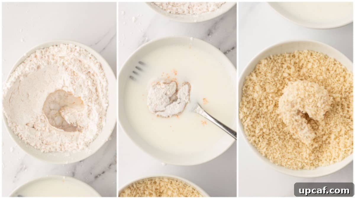 Close-up of shrimp being coated with breadcrumbs for air frying.