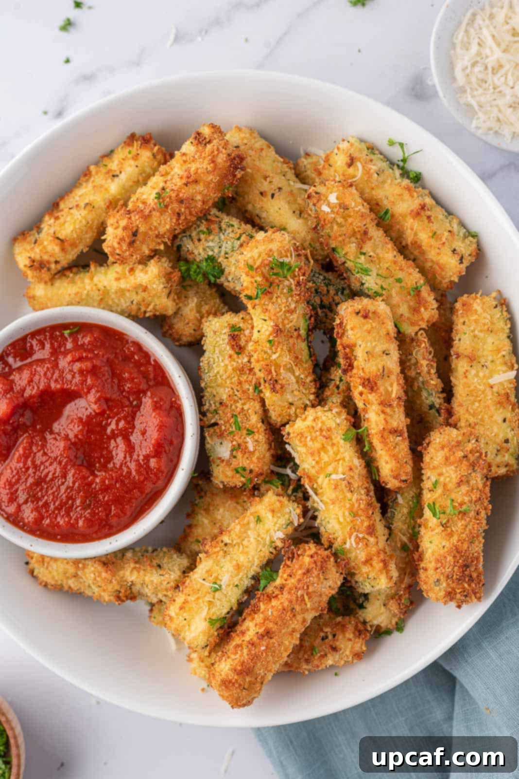 Crispy Air Fryer Zucchini Sticks served on a plate with marinara dipping sauce.