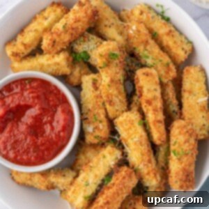 Crispy Air Fryer Zucchini Sticks served on a plate with marinara dipping sauce.