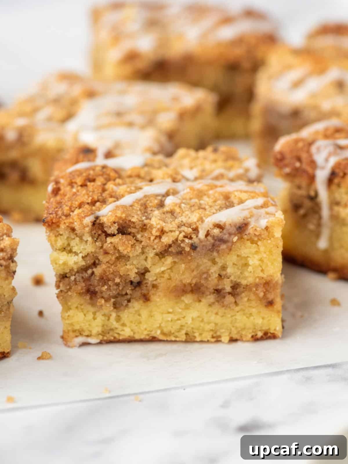 Perfectly cut squares of keto coffee cake arranged neatly on parchment paper, showcasing the delicious streusel topping and moist texture of the almond flour cake.