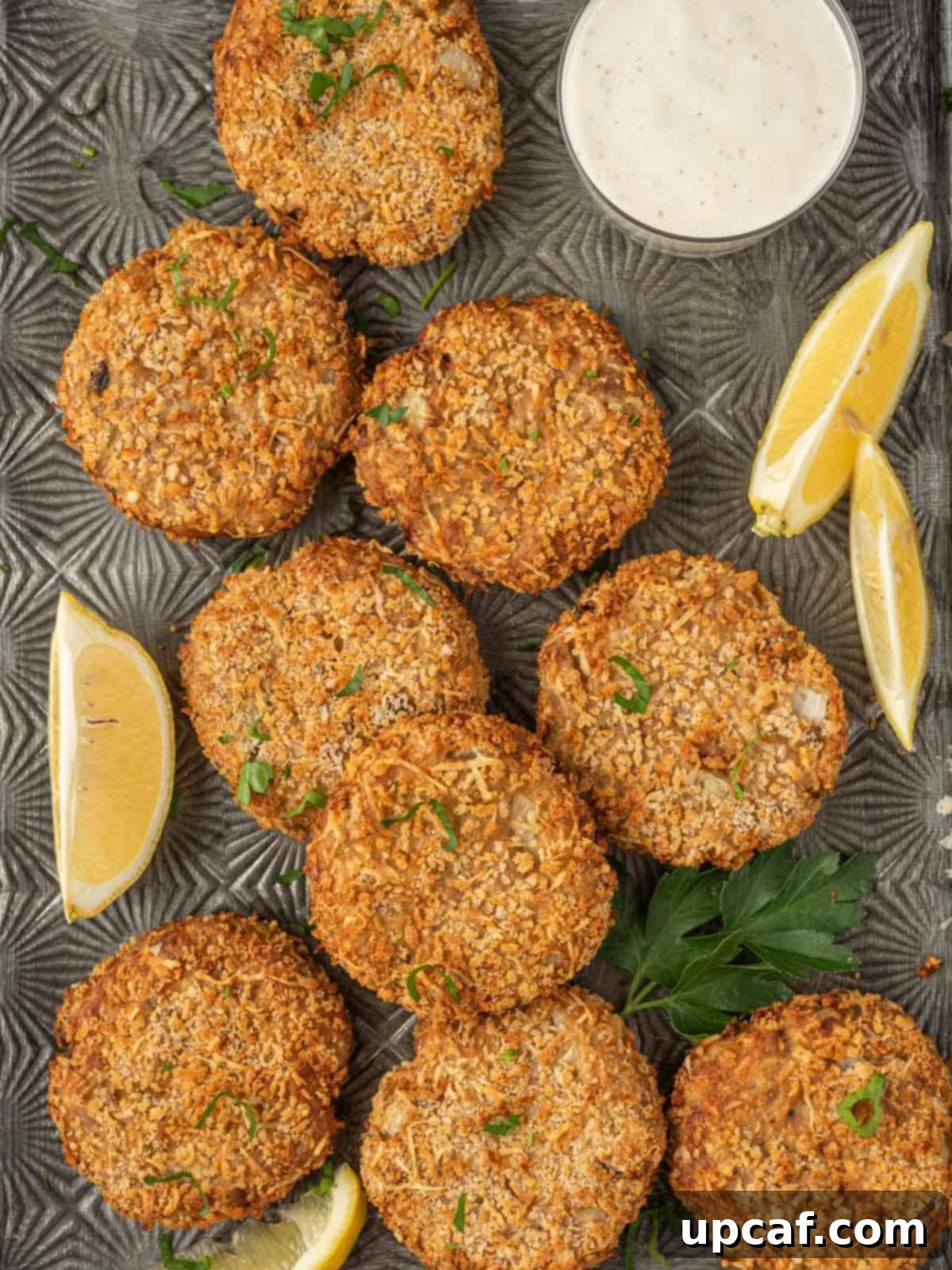 Air fryer tuna patties ready for serving, garnished with fresh parsley and lemon wedges.