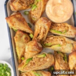 Seafood Egg Roll Recipe air fried and served cut in half on a tray with dipping sauce.