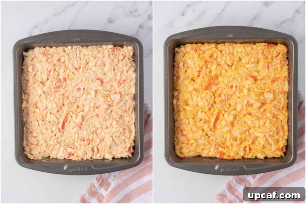Spicy imitation crab mixture spread over seasoned rice in a casserole dish before baking.