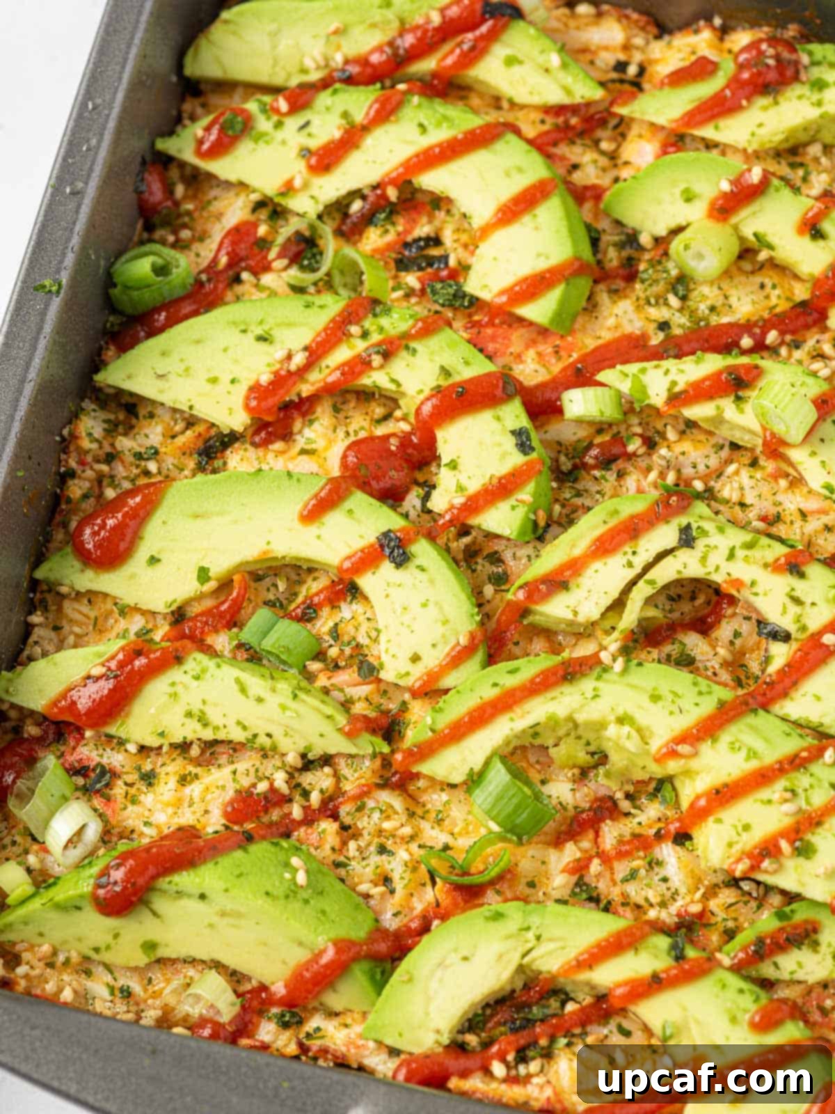 Close-up view of a freshly baked imitation crab sushi bake, showing the golden top layer.