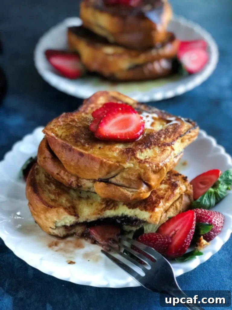Decadent Strawberry Nutella French Toast 2 Strawberry Nutella French Toast served on a plate with a fork, ready to be enjoyed.