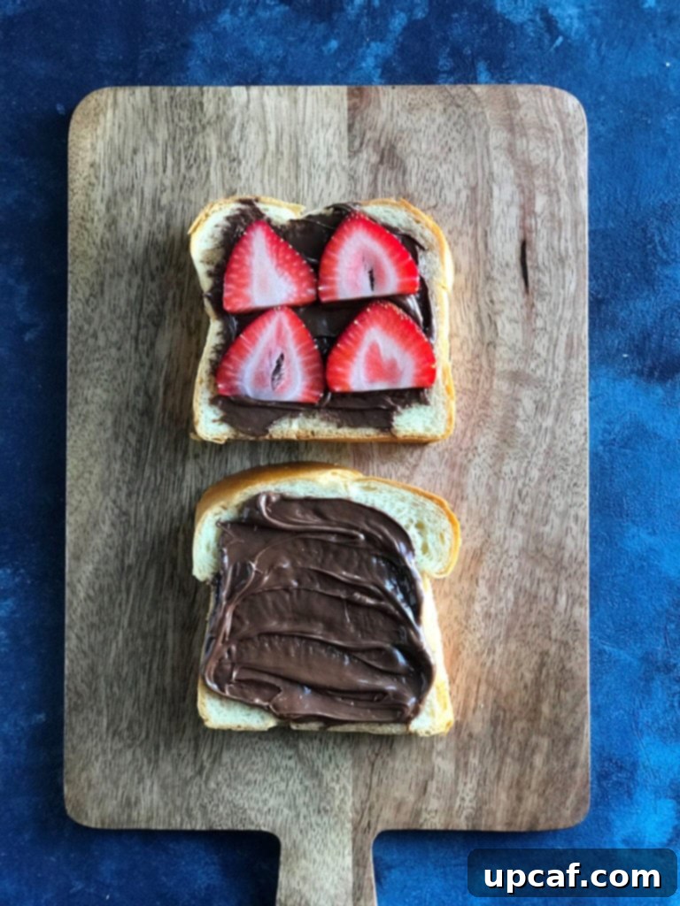 Decadent Strawberry Nutella French Toast 3 Top down view of Nutella spread generously on a slice of brioche bread.