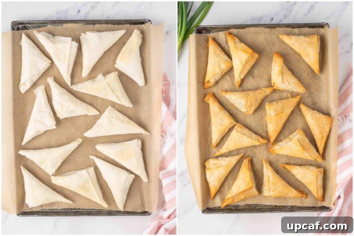 Quick & Easy Spanakopita Bites 7 A baking sheet filled with perfectly formed, unbaked spanakopita triangles, brushed with butter and ready for the oven.