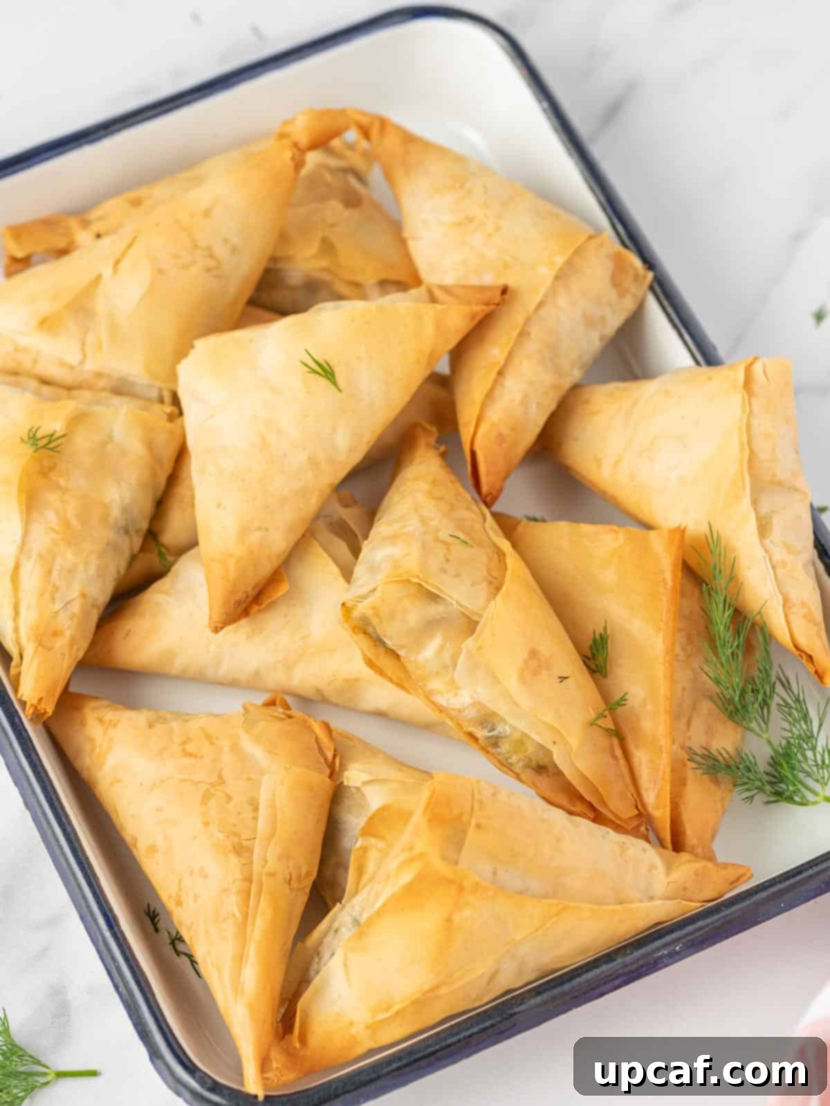 Quick & Easy Spanakopita Bites 10 A tempting tray of freshly baked easy spanakopita triangles, ready for serving.