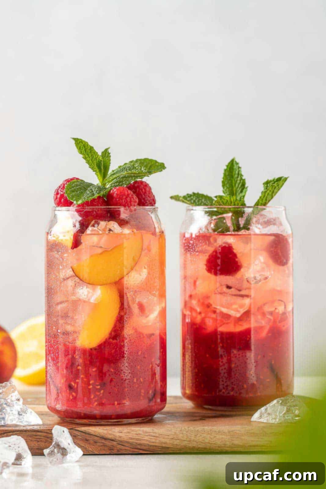 Raspberry Peach Sunburst Quencher 9 Two glasses of Raspberry Peach Lemonade Cooler, beautifully garnished and ready to serve.