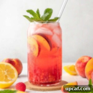 Raspberry Peach Sunburst Quencher 10 peach raspberry lemon in a cup with a glass straw