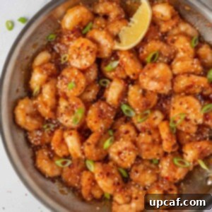 Blazing Burst Shrimp 11 Garnished firecracker shrimp in a skillet with a lemon wedge.