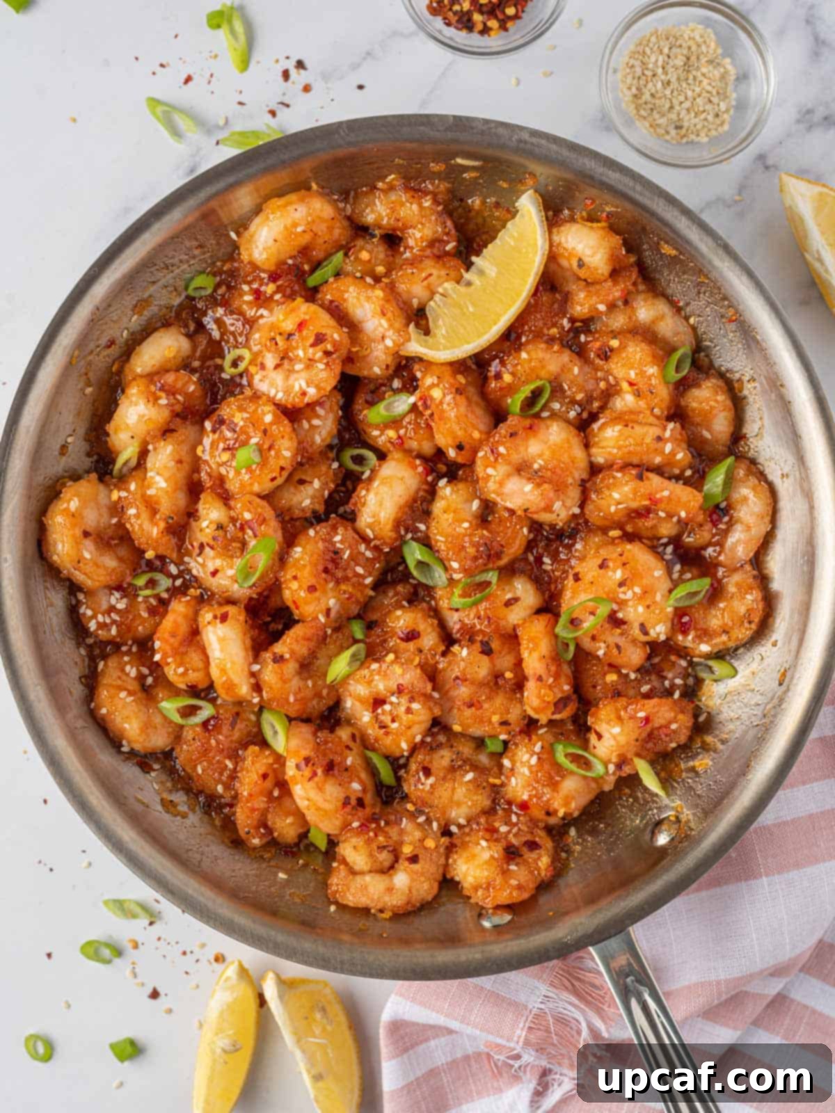 Blazing Burst Shrimp 8 Delicious spicy fried shrimp with firecracker sauce beautifully arranged in a skillet, garnished with fresh greens.