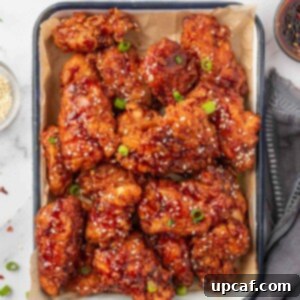 Addictive Crispy Korean Fried Chicken 13 Chicken tenders coated with gochujang sauce on a tray.