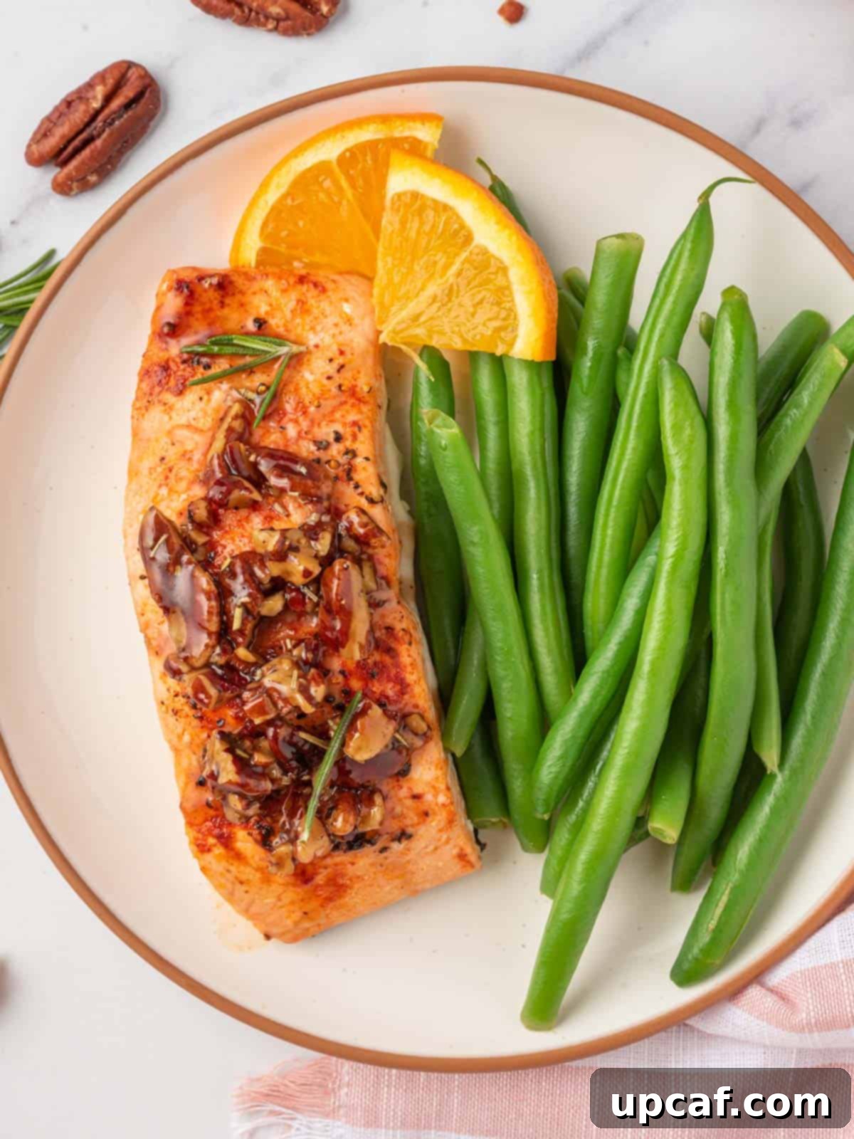 Caramelized Maple Pecan Salmon 8 A plate featuring glazed salmon with pecans, accompanied by fresh green beans.