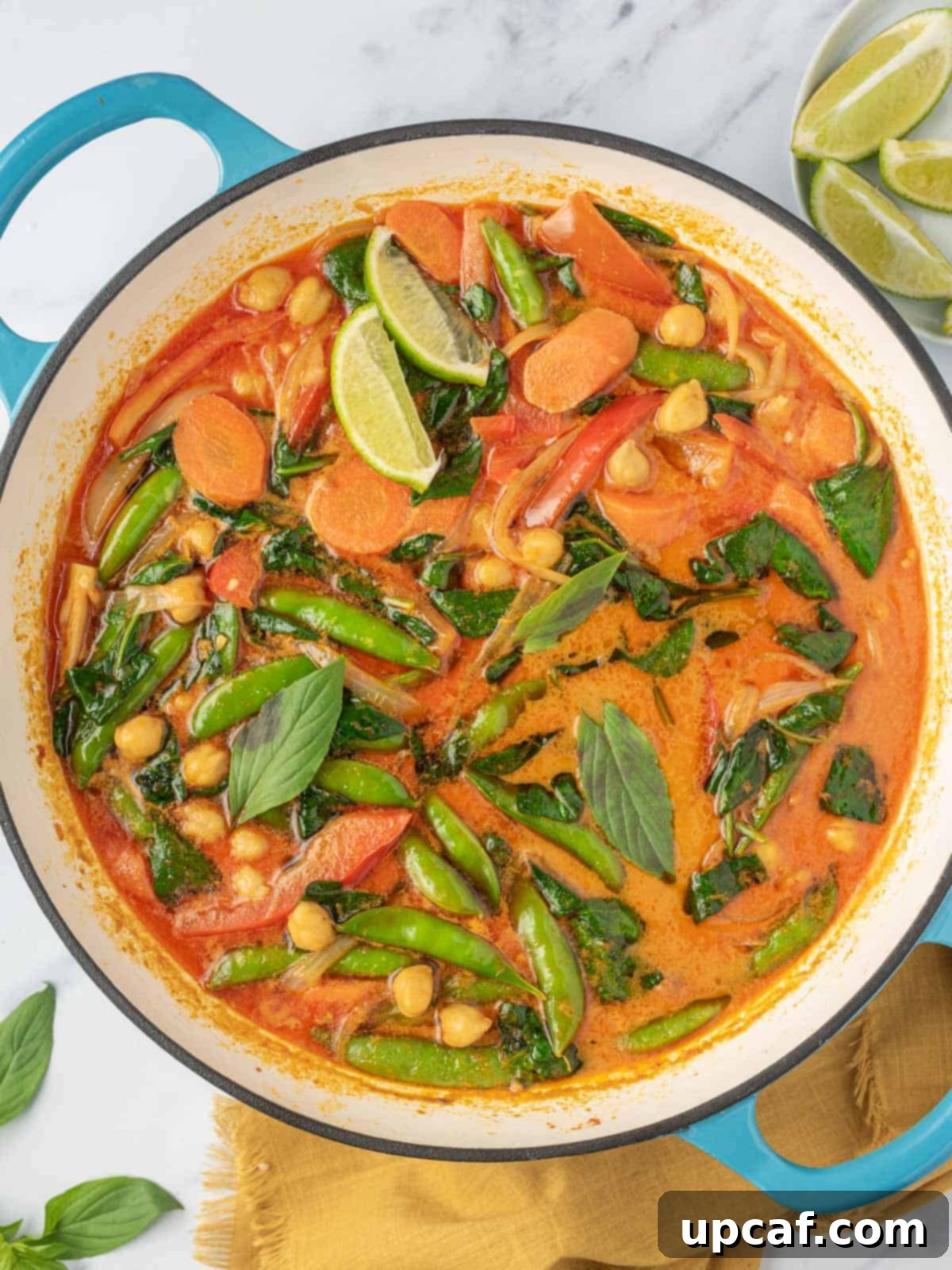 Vibrant Red Thai Plant-Based Curry 6 A large pot generously filled with steaming, rich, and authentic Thai red curry, ready to be served, showcasing its beautiful reddish hue, creamy texture, and a medley of colorful vegetables and herbs.