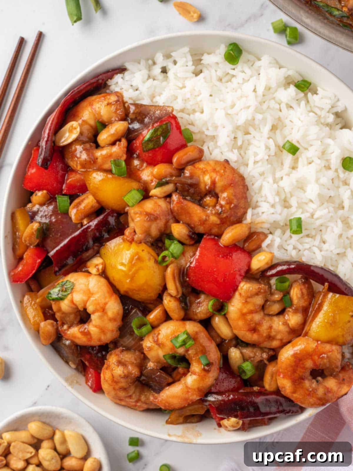 A vibrant bowl of spicy shrimp stir fry with rice, beautifully presented as a delicious Chinese meal.