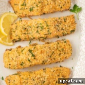 Crispy baked salmon fillets on a platter with lemon slices.