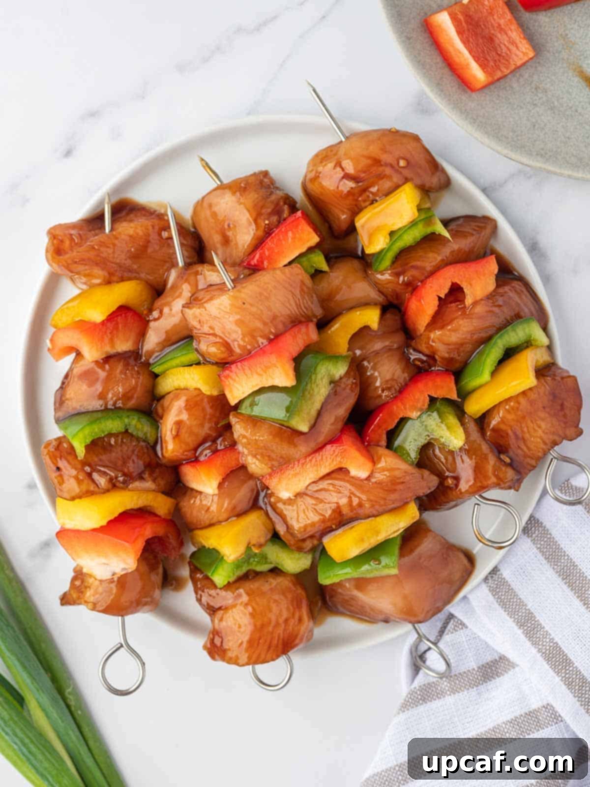 Sweet and Sticky Teriyaki Chicken Skewers 6 Assembling marinated teriyaki chicken skewers with bell peppers.