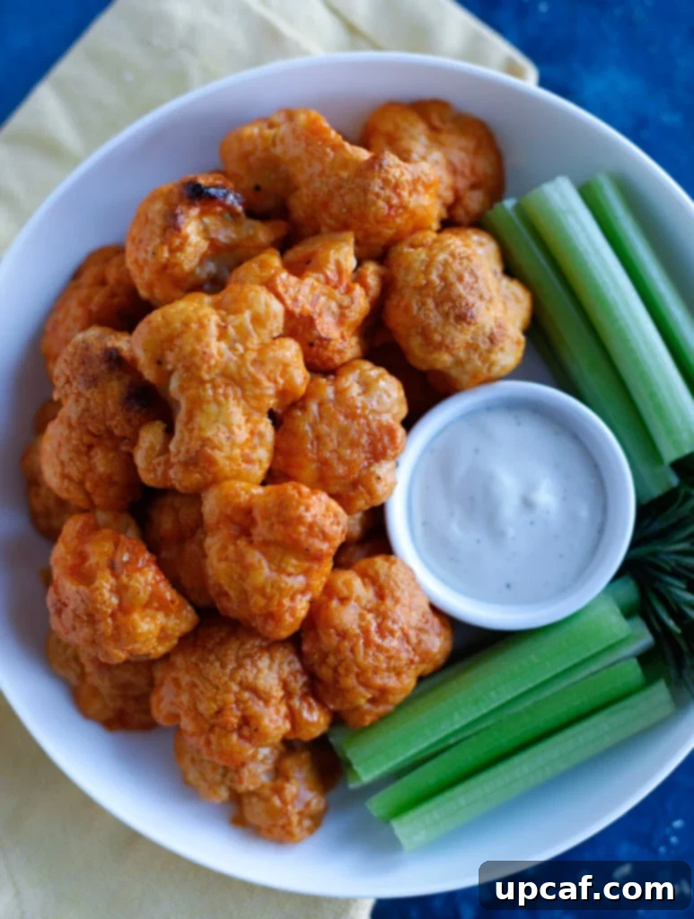 Crispy Buffalo Cauliflower Wings on a plate with creamy ranch dip and fresh celery sticks, ready to be enjoyed.