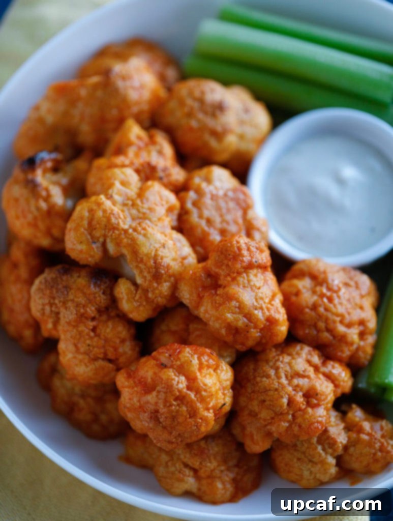 Close-up shot of hot, saucy Buffalo Cauliflower Wings served on a platter, highlighting their texture and appealing glaze.