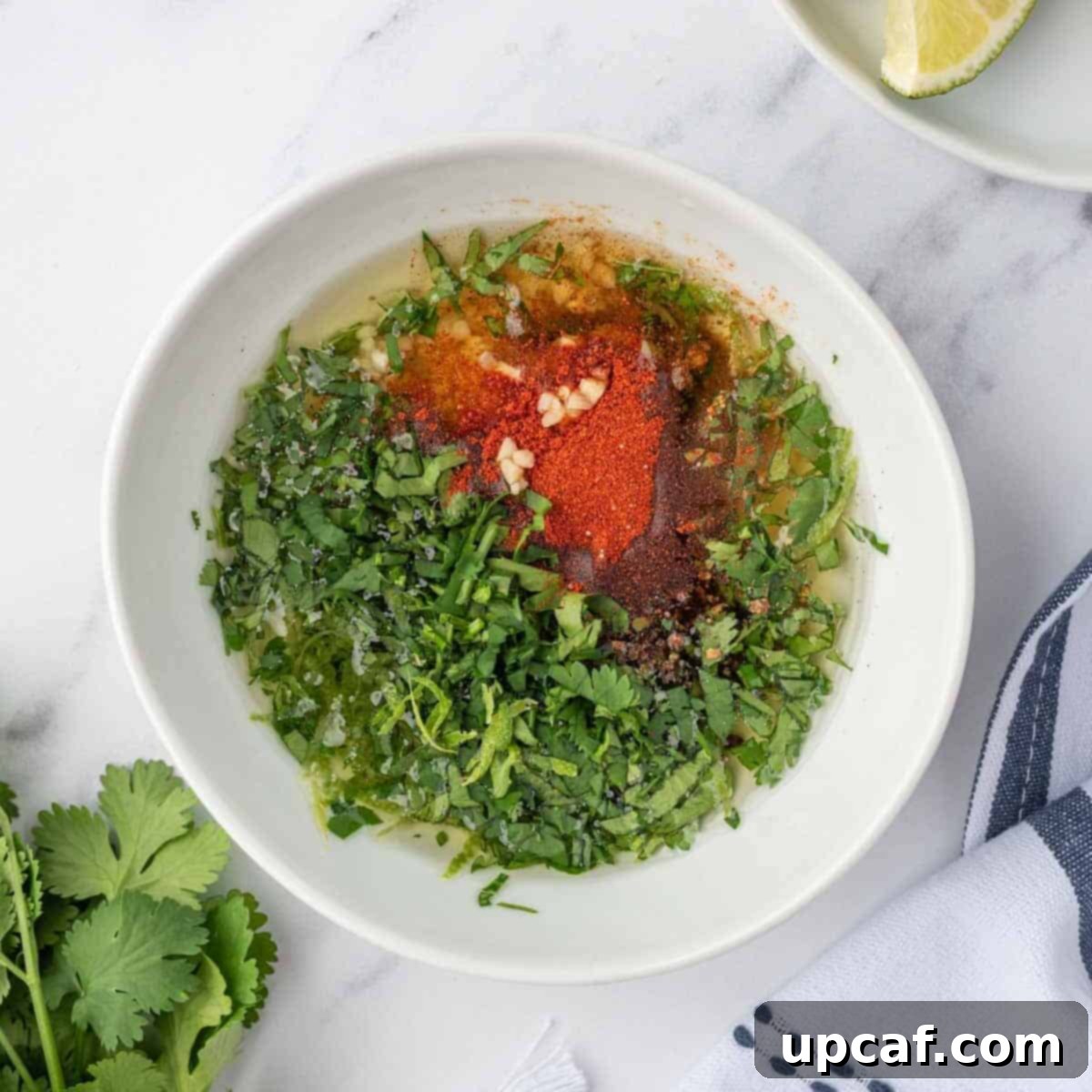 A small bowl containing the freshly prepared cilantro lime marinade for chicken drumsticks, showing chopped cilantro, lime juice, and spices.