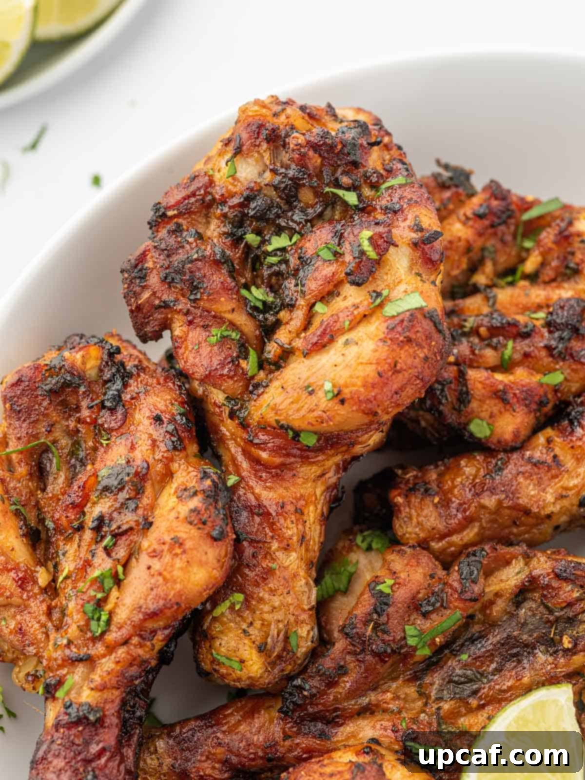 A close-up shot of crispy cilantro lime air fryer chicken drumsticks garnished with fresh cilantro, ready to be served.