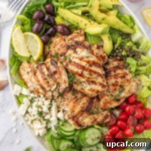 Greek chicken salad recipe on a platter with dressing on the side.