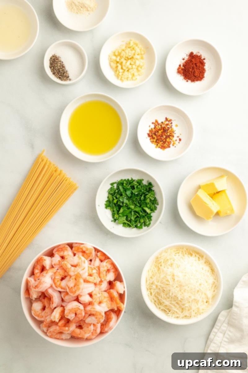 A visual spread of fresh ingredients for Garlic Parmesan Shrimp Spaghetti, including spaghetti, raw shrimp, garlic, lemon, and spices.