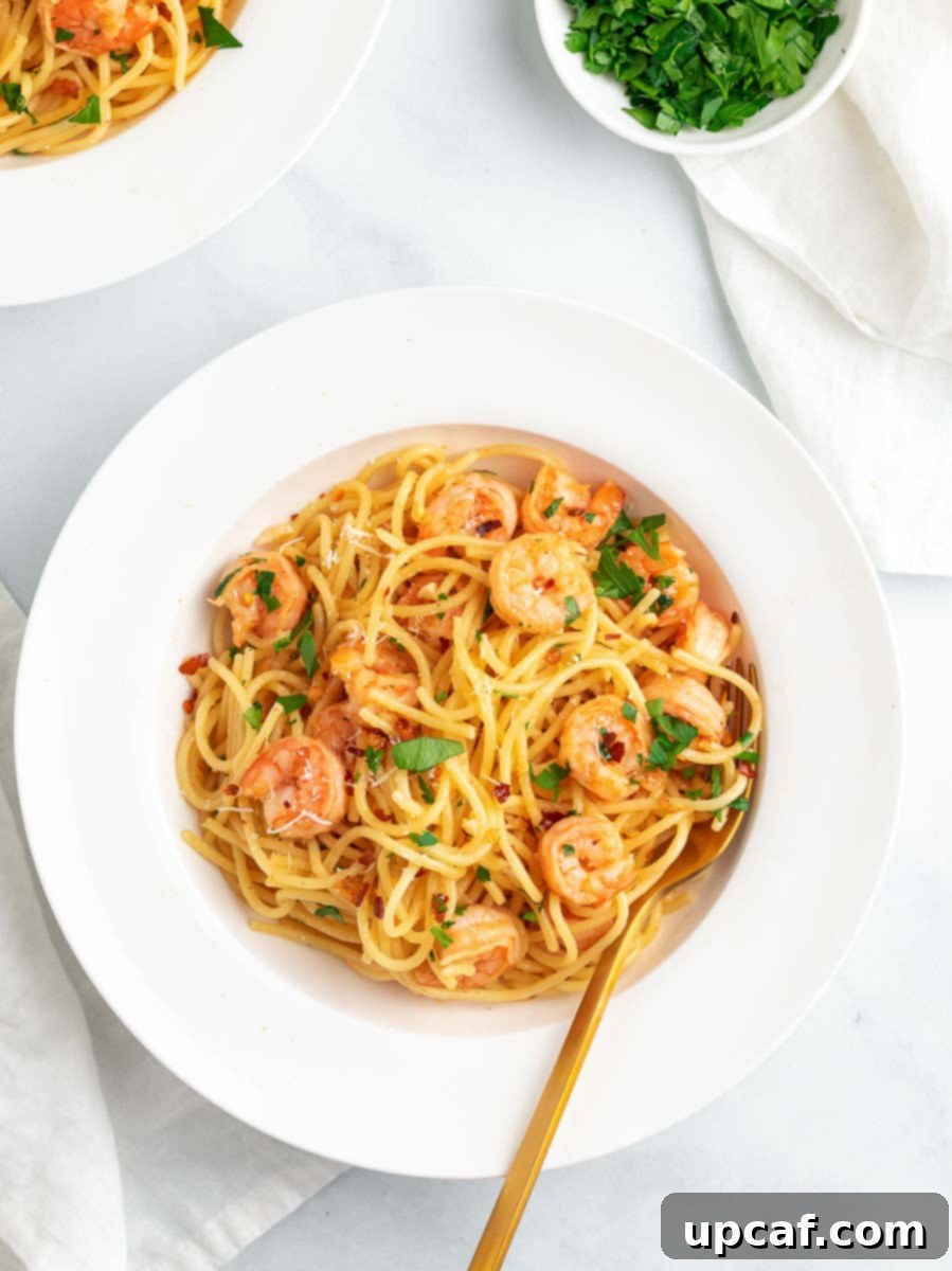 A close-up of Garlic Parmesan Shrimp Spaghetti served in a white bowl, showing tender shrimp and perfectly coated pasta.