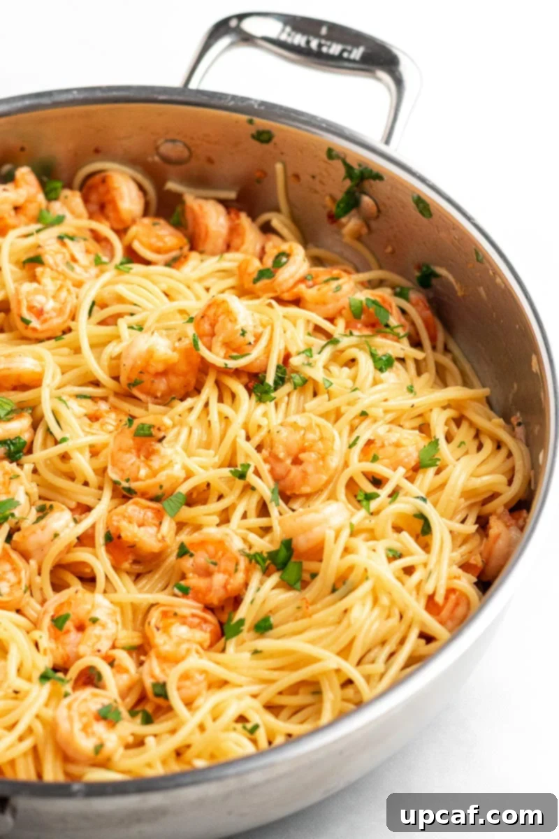A side view of the delicious Garlic Parmesan Shrimp Spaghetti in a skillet, showcasing the tender shrimp and rich sauce.